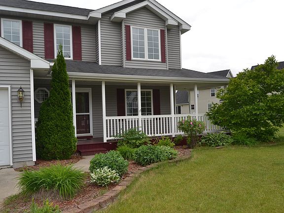 The front walk way leads up to the homes wrap around front porch.  A great spot for a seating area to enjoy the summer evenings.  The landscaping is already in place for you to enjoy.