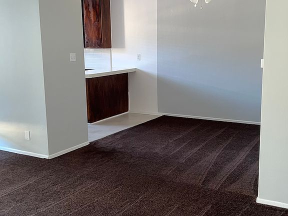Living room with dinette and ceiling fan leading to the kitchen