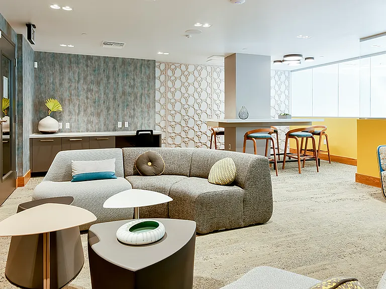 Resident lounge with ample social seating and wall-mounted television