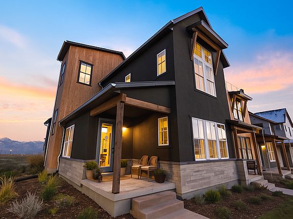 Modern two-story house with dark exterior, large windows, and wooden accents. A small porch with cha