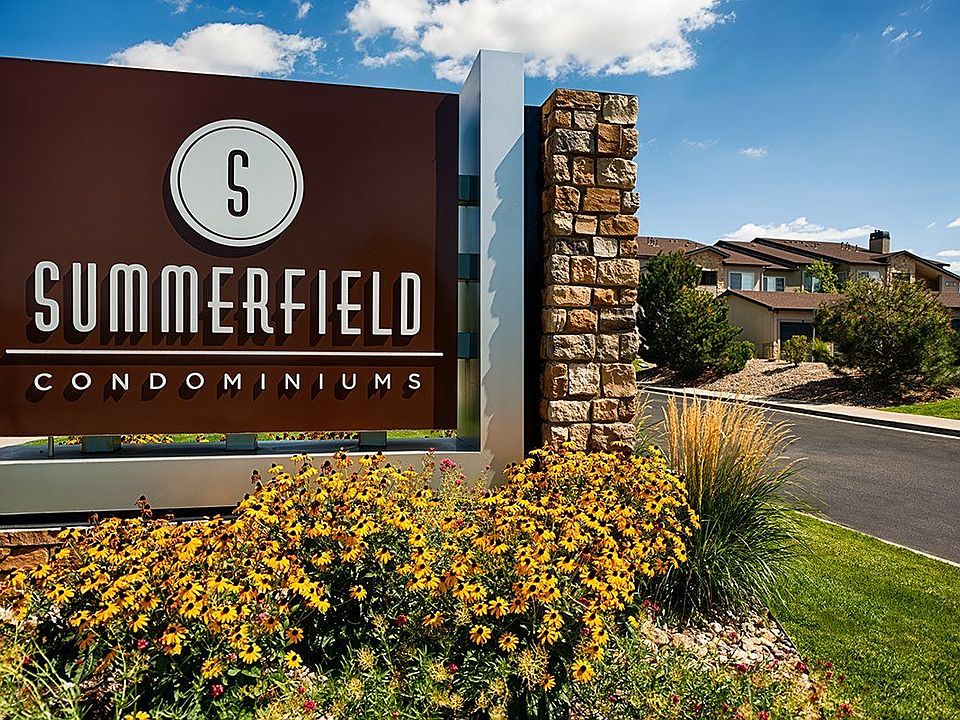 Front entrance monument sign with beautiful flowers in a flower bed.