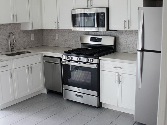 NEW eat in kitchen with stainless appliances, dishwasher, and quartz countertops