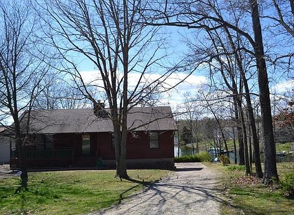 Front exterior with driveway leading to rear entry garage and lake access