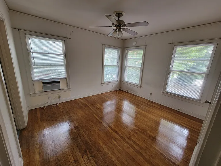 Bedroom: Natural light from ample windows, Hardwood floors, Window air conditioner, Ceiling fan; 1 closet