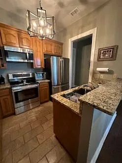 Kitchen has granite counter tops; french door refrigerator with automatic ice maker; large single stainless steel sink with pull-out faucet and reverse osmosis for drinking water. Floor is sealed stone.