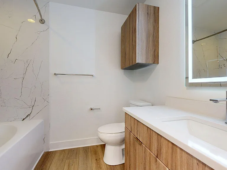 Apartment Bathroom with large soaking tub, Sink, LED vanity mirror and wood style flooring