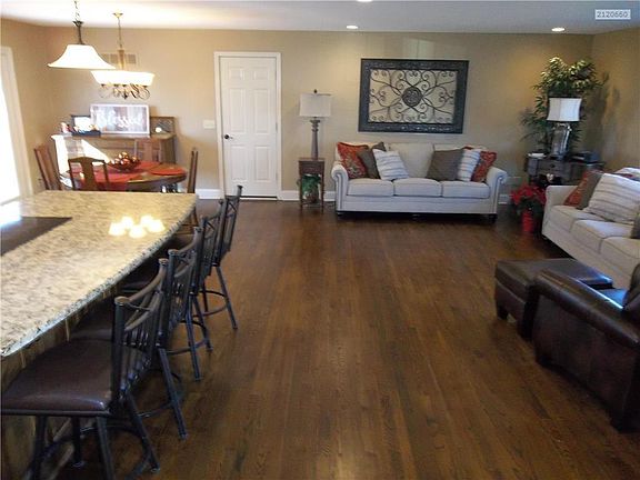 Kitchen, Island w/ Bar and Dining area on left and Living Room on right.