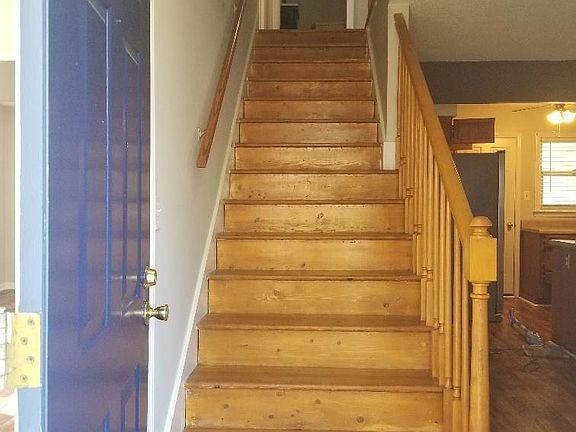 Front entry door. To the right is dining or living area and the kitchen