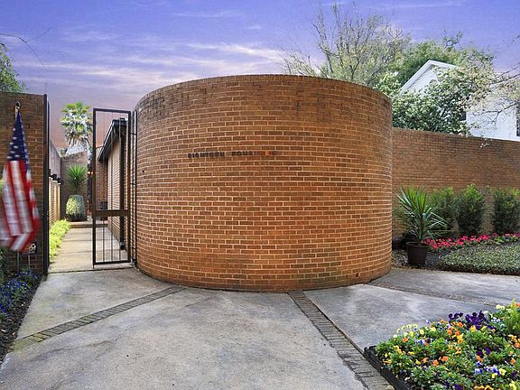 The exterior of the home is brick and redwood. Note the private gated entrance with llighted brick wall and landscaped walk way.