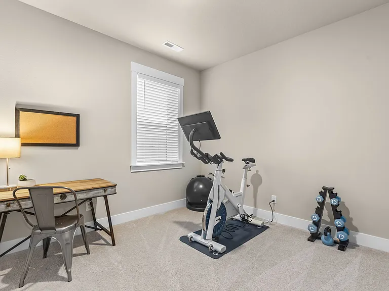 Main Floor bedroom or office with closet and custom shelving and hanging space.