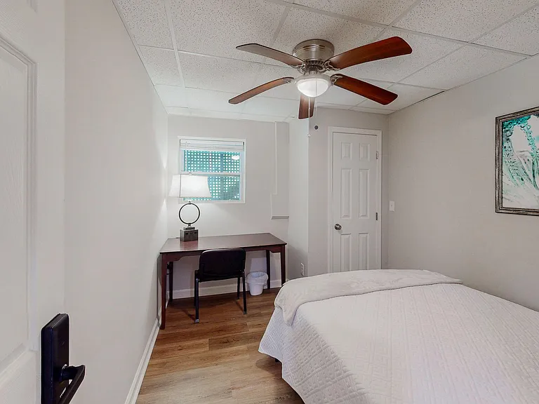 Bedroom with a ceiling fan, window, closet and a dedicated desk areaideal for work-from-home routines and everyday comfort.