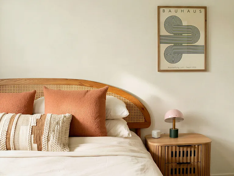 Serene primary bedroom with warm wood accents, layered textures, and a calm, modern aesthetic
