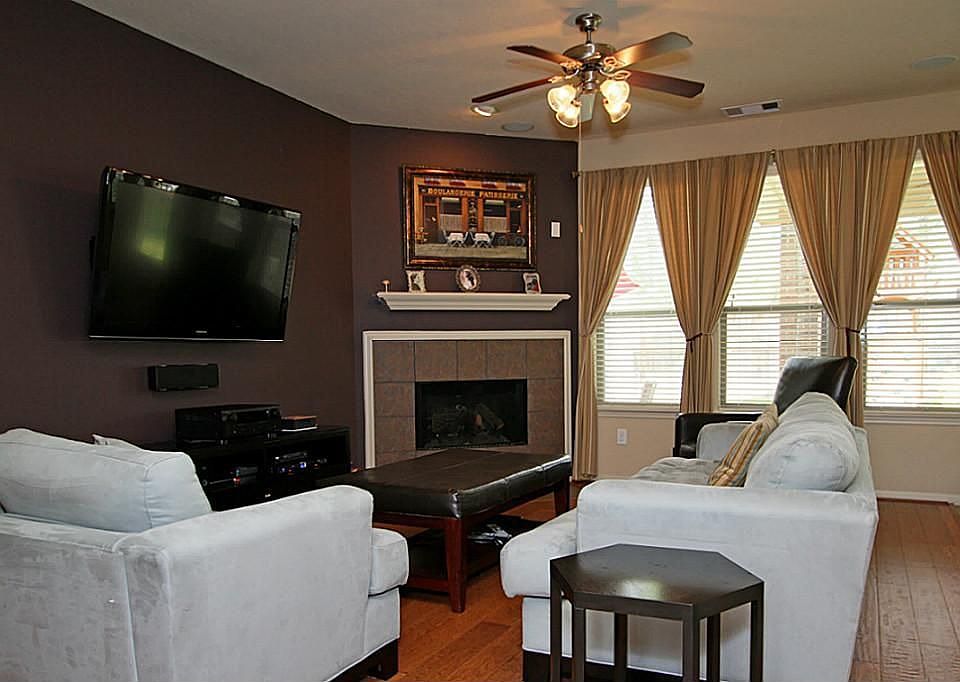 Family room has custom paint and a cozy fireplace.