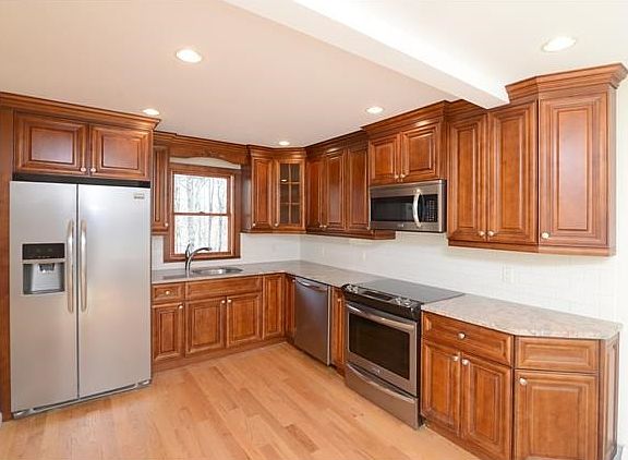 Stainless steel appliances, custom kitchen with matching crown molding and unique granite top.