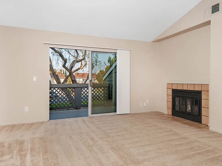 Carpeted Living Room with Fireplace and Balcony