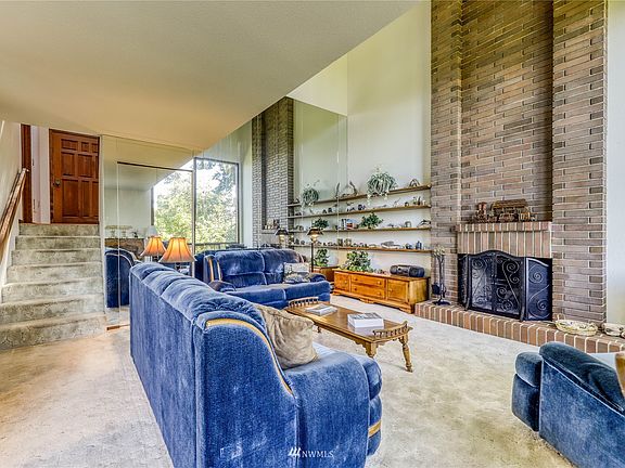 Coming down into the living area of the condo.  The living room is anchored by a brick wood-burning fireplace.>