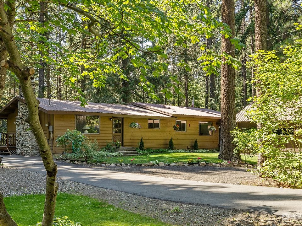 This charming ranch-style home is nestled in a picturesque, park-like setting.>