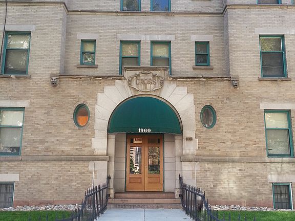 Historic brick apartment facade with green awnings and well-maintained entrance.