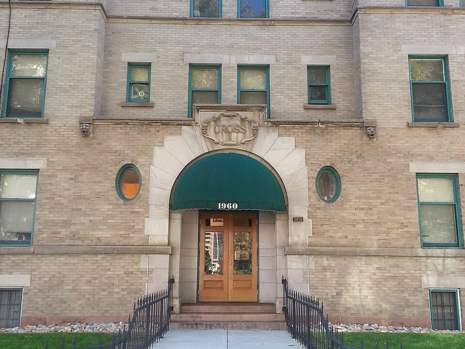 Historic brick apartment facade with green awnings and well-maintained entrance.