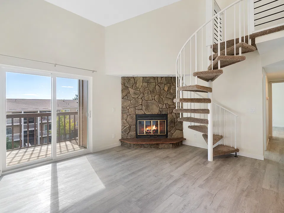 Large living room with vaulted ceiling, plenty of light, and functioning wood burning fireplace for cozy winter evenings