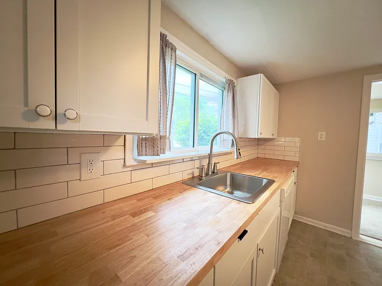 Brand new white shaker cabinets, backsplash, sink/faucet, and butcher block countertops