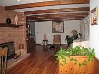 Beamed ceiling & gleaming hardwood floors in living room