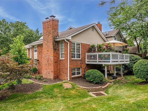 A view from the side shows off the beautiful landscaping and gorgeous deck