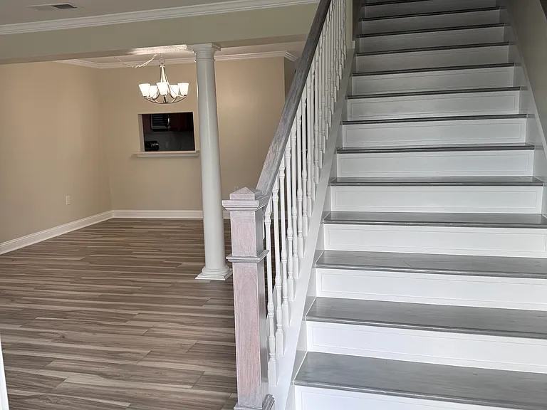 Entryway with wooden stairs leading to the second floor.