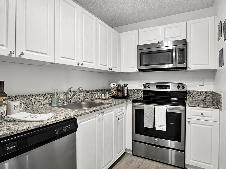 Model Unit 119 - Kitchen with Granite Countertops and Stainless Steel Appliances