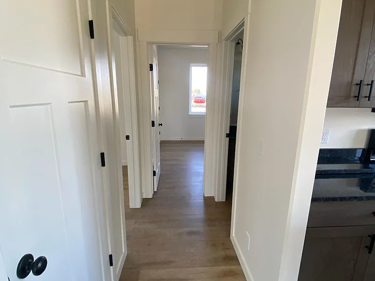 Hallway with bathroom and two bedrooms off kitchen