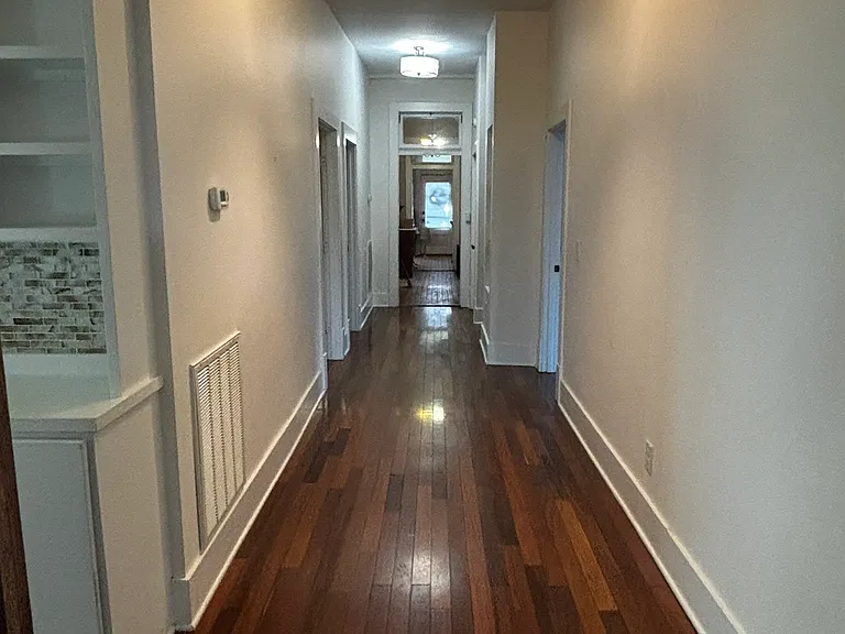 Wide hallway features access to all bedrooms, storage closet and built-in shelves.