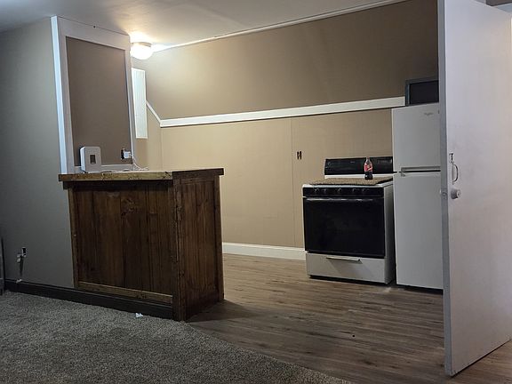 Kitchen has stove, refrigerator and microwave.