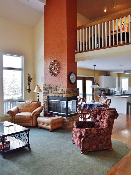 This great room has terrific views- inside and out!  The two-way fireplace provides warmth for both the great room and informal eating area and lets the cook join in the activity.