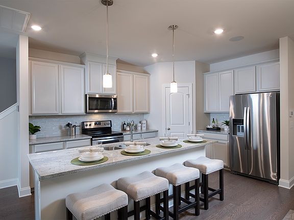 The sprawling kitchen island overlooks the open-concept dining and great rooms.
