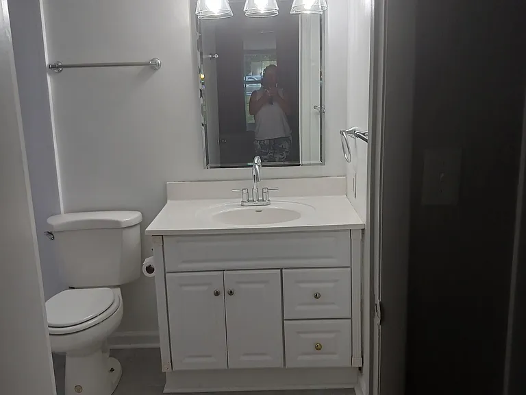 Master bath with walk-in shower, new terrazzo floors, vanity, and lighting. Grab bars in shower for safety.