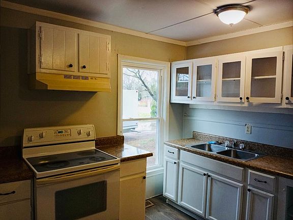 Kitchen with new paint and window. Stove and Fridge included with rental