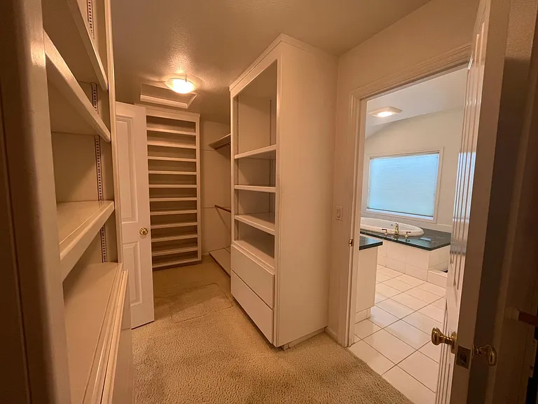 Extra-large primary walk-in closet has built-in organized storage.