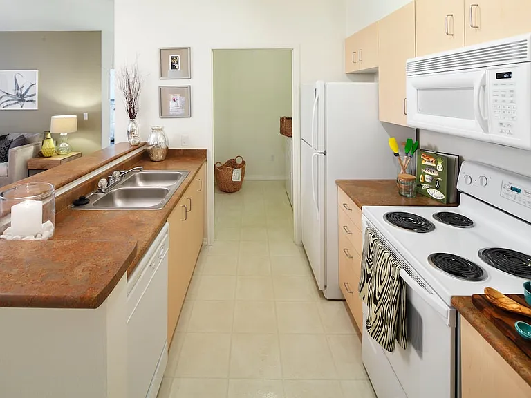 Classic Package I kitchen with oak cabinetry, laminate countertops, white appliances, and hard surface flooring