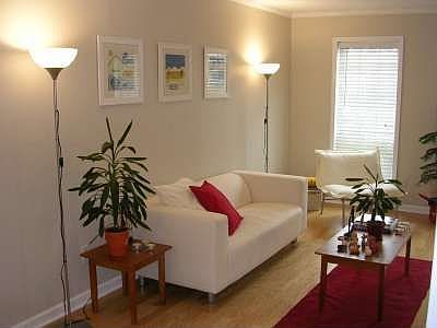 The spacious living room features hardwoods, large windows and 9 foot ceilings