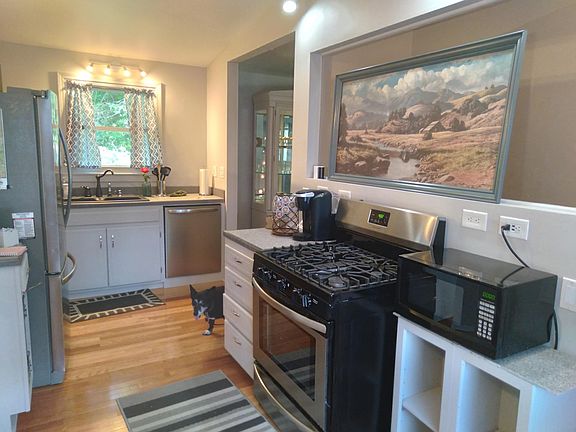 The kitchen has a gas stove, large fridge, dishwasher, garbage disposal and views of front and back yard.