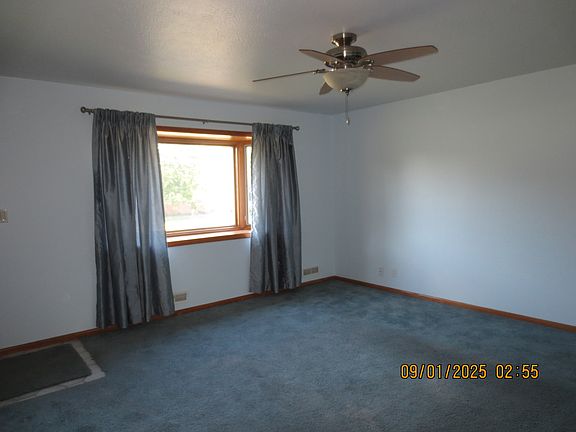 Living room with Pella bay window and ceiling fan.