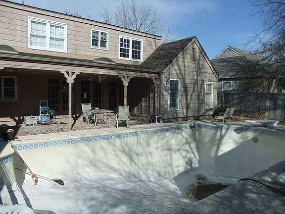 Back of home with view of the pool. Play area beyond pool.