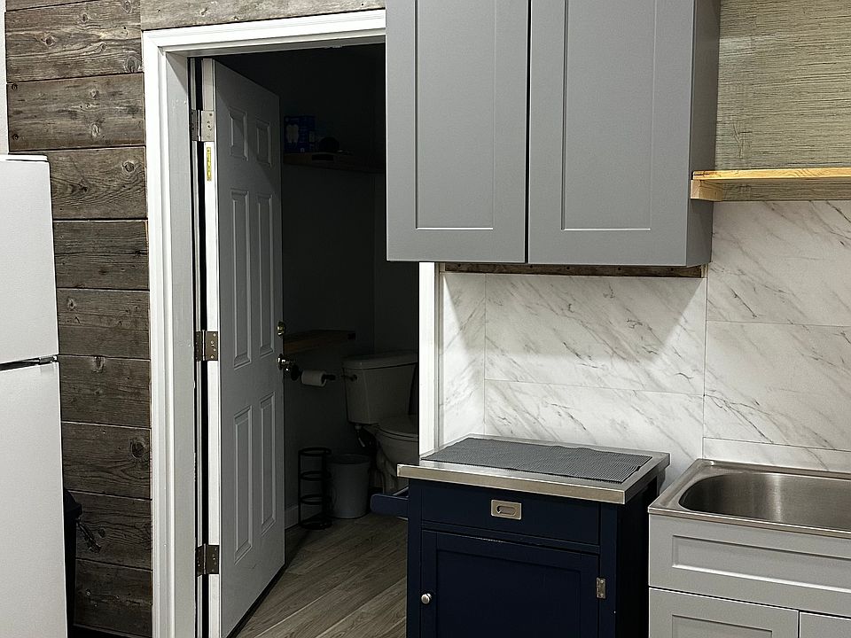 Reclaimed barnwood accent wall with full size fridge in your efficiency kitchen.