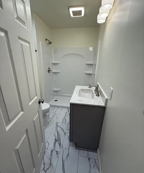 Newly renovated bathroom, all new surfaces, flooring, vanity cultured marble sink, toilet, shower stall, Moen fixtures, new light fixtures, fan.