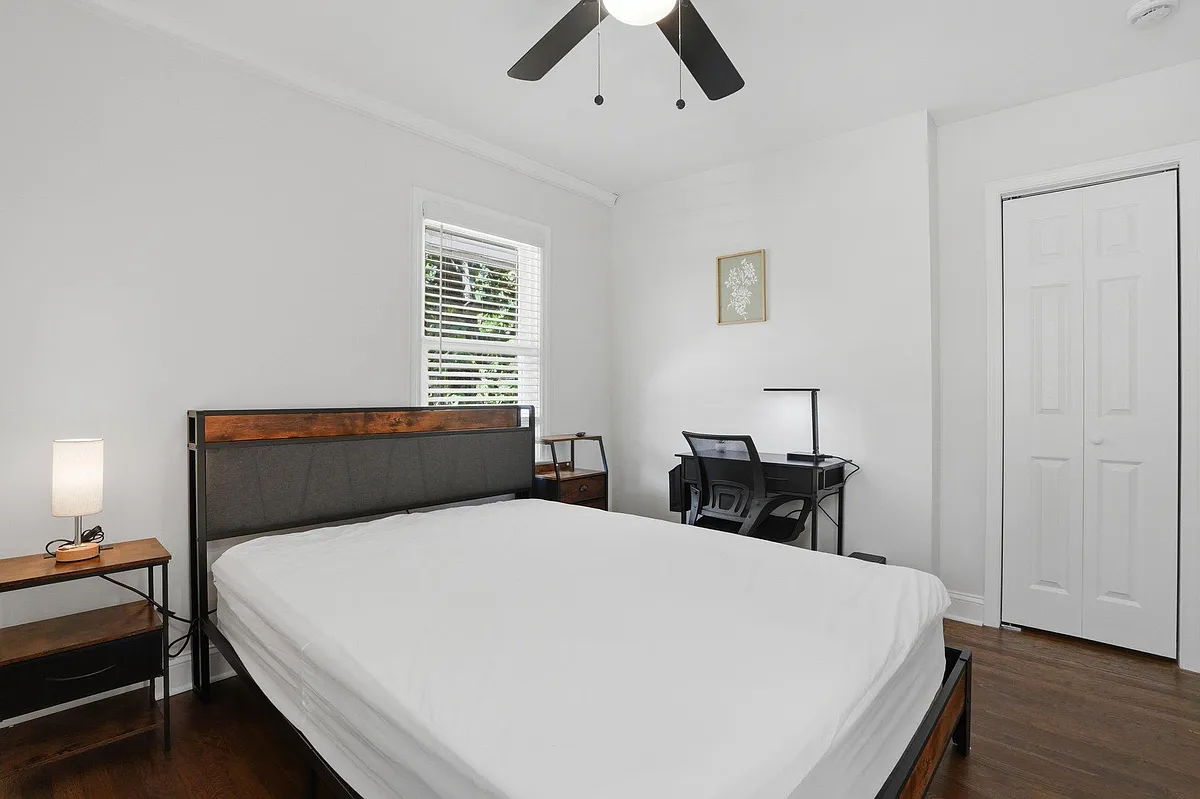 Private bedroom with a comfortable bed, desk workspace, ceiling fan, and closet, plus window blinds for light control. - Dodson Dr SW