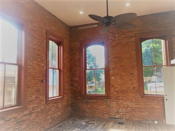 Living room walls are exposed brick. Really tall 14-ft. ceilings