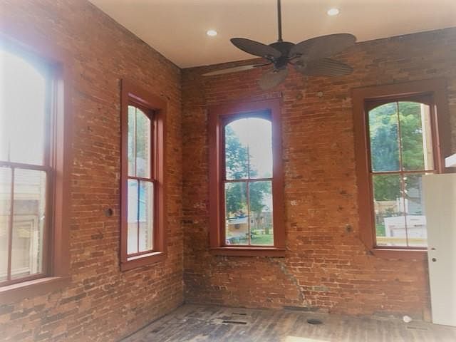 Living room walls are exposed brick. Really tall 14-ft. ceilings