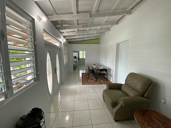 Living room with recliner, dining table and chairs, french doors leading to the balcony.