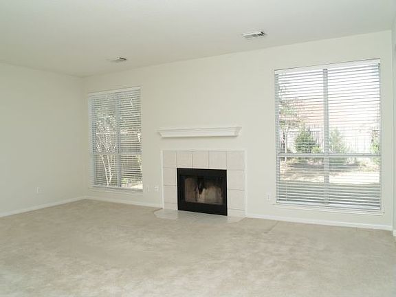 Living room, with tiled fireplace, gets plenty of natural light.