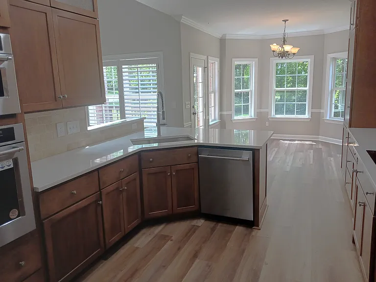 Kitchen includes maple cabinets, quartz countertops and stone backspashes.
